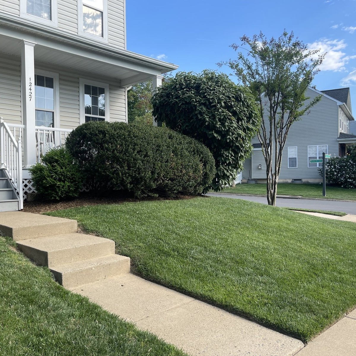 Trusted Lawn Care in Wells, ME featuring a freshly maintained green lawn, neatly trimmed shrubs, and a professionally landscaped front yard by All Natural Landscaping.