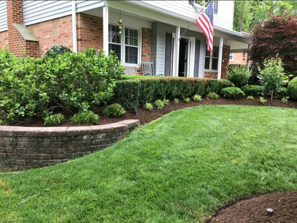 Landscaped residential lawn with trimmed shrubs and garden beds for lawn care services in Rye, NH